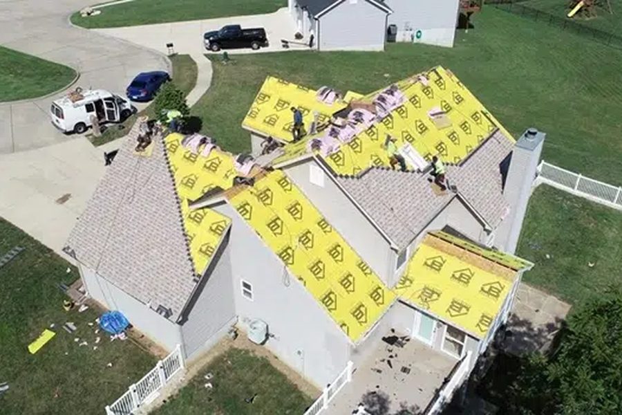 Crew installing shingles over underlayment on an Indianapolis roof replacement