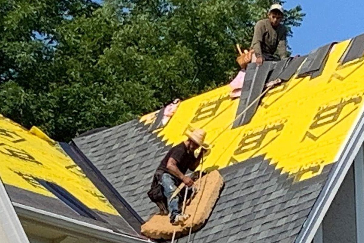 Roofing contractors working on a residential roof in the Indianapolis metro