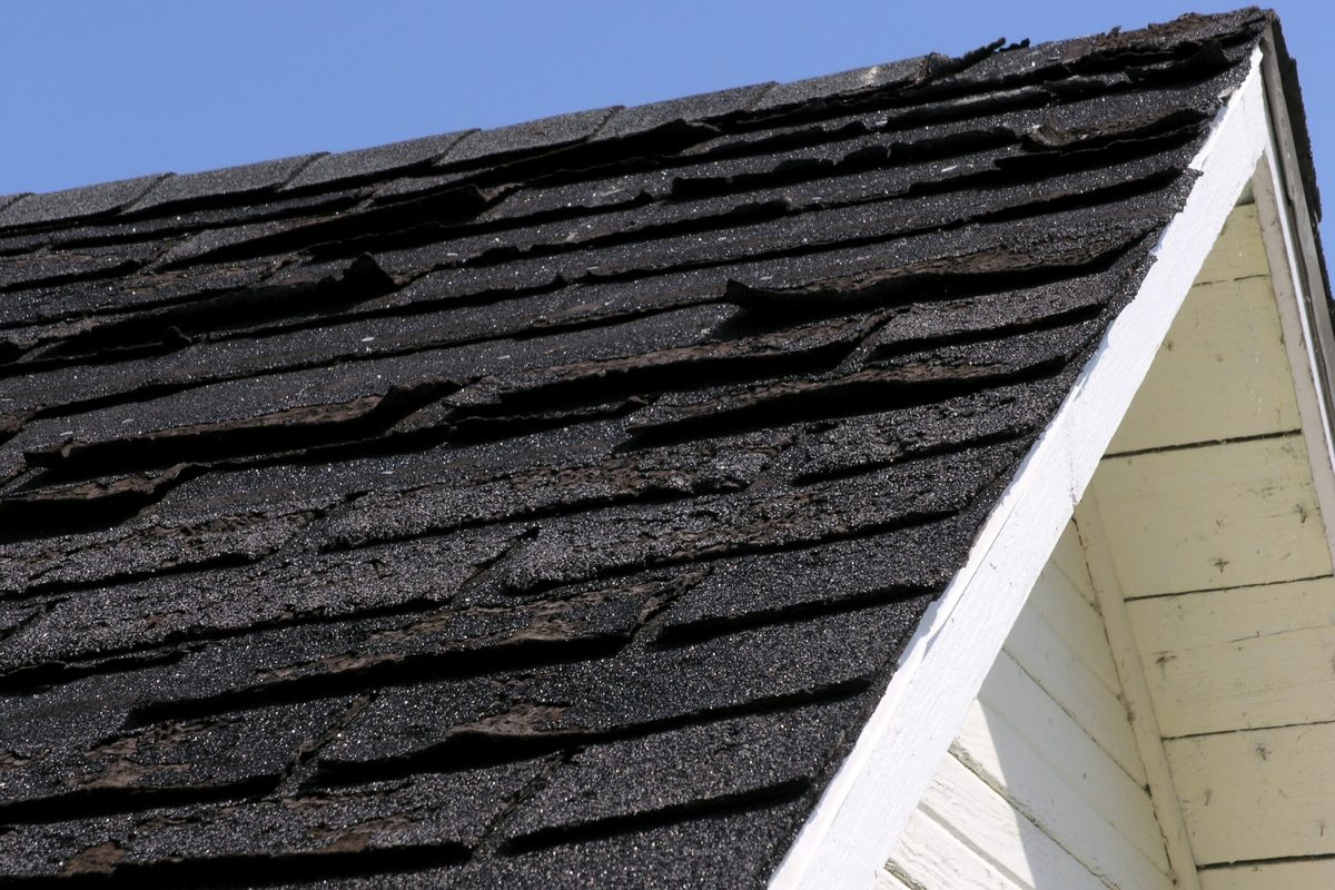 Storm damaged asphalt shingles torn loose on an Indianapolis roof