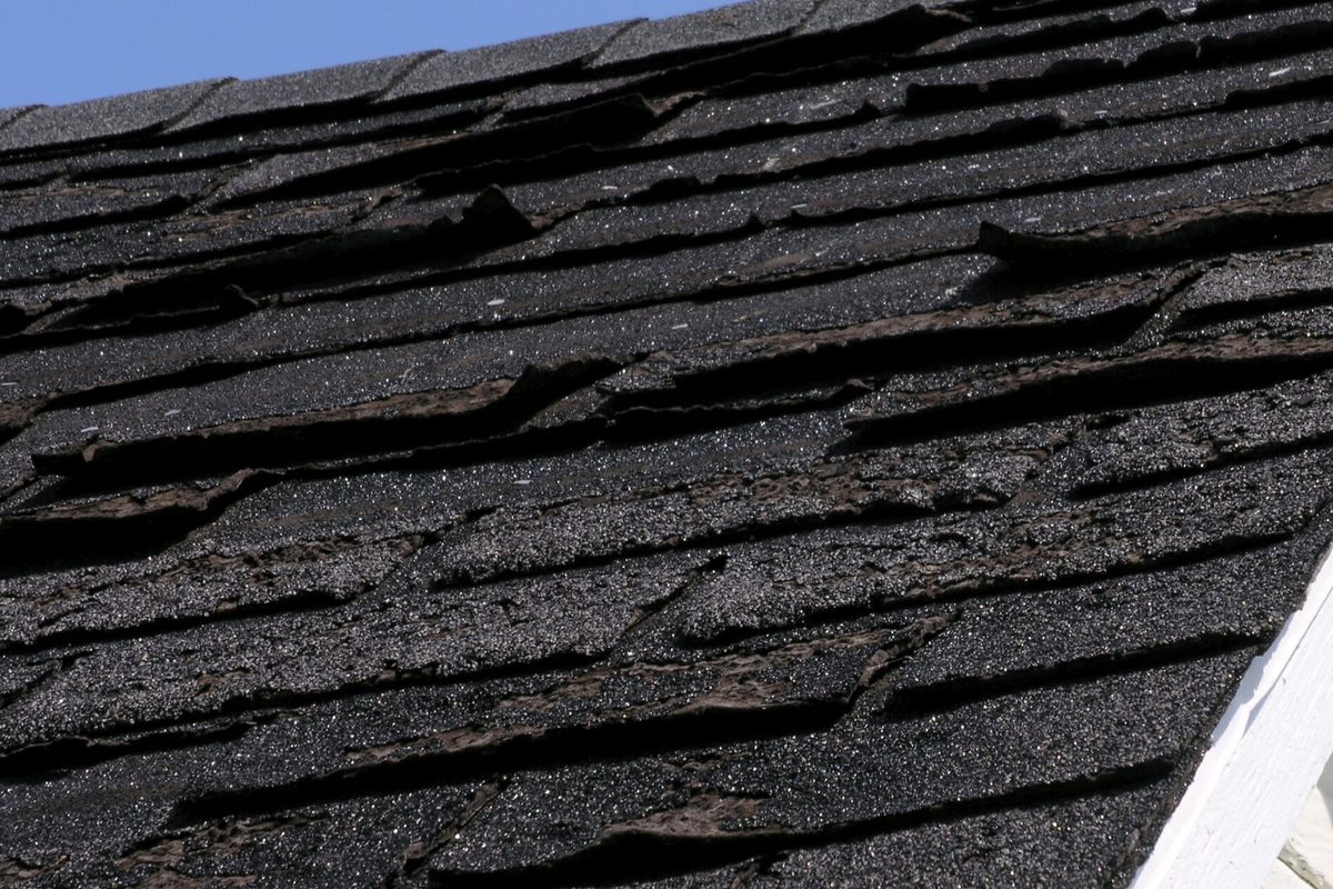 Wind lifted and missing shingles on an Indianapolis area roof after a storm